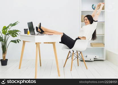 woman stretching arms sitting table office