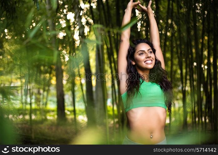 Woman stretching her arms in bamboo garden
