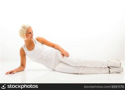 Woman stretching her body fitness exercise lying on white floor