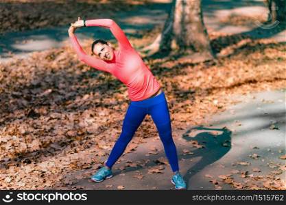 Woman Stretching in the Park After Jogging.. Woman Stretching in the Park.