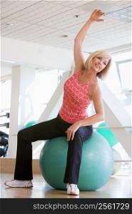 Woman Stretching On Swiss Ball At Gym
