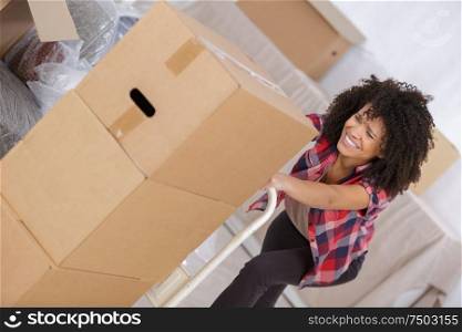 woman struggling carrying heavy carton box with furniture