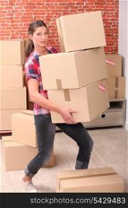 Woman struggling to carry boxes