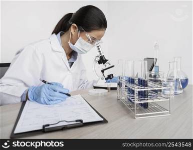 woman studying chemical elements with microscope