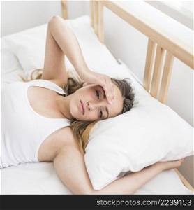 woman suffering from headache lying bed