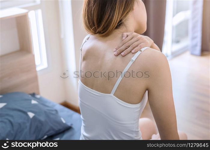 Woman suffering from neck pain on the bed, healthcare and problem concept. Woman suffering from neck pain on the bed