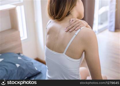 Woman suffering from neck pain on the bed, healthcare and problem concept. Woman suffering from neck pain on the bed