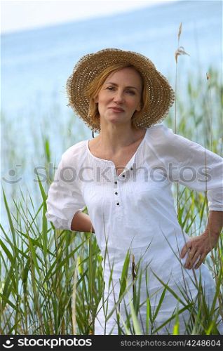 Woman surrounded by reeds near a lake