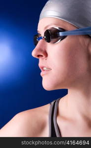 woman swimmer is looking sideways on blue background