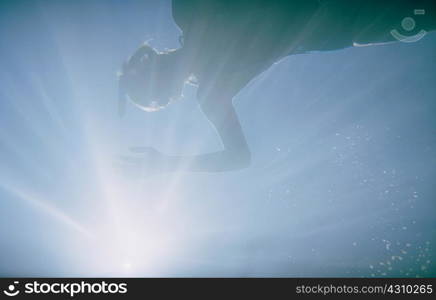 Woman swimming in sea with sunlight