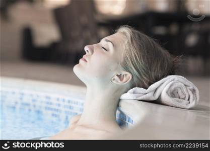 woman swimming pool leaning her head edge rolled up towel