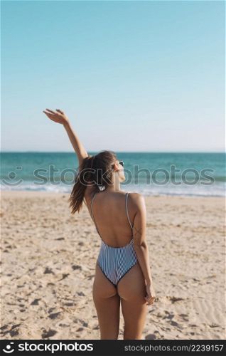woman swimsuit waving hand seaside