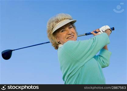 Woman Swinging Golf Club