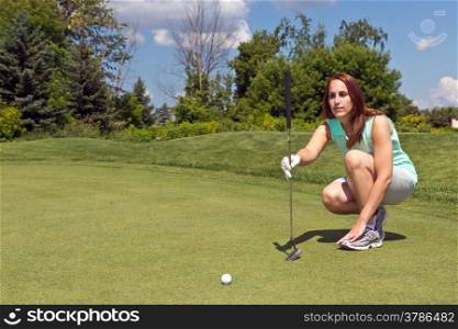 Woman takes aim for her putt on the golf green