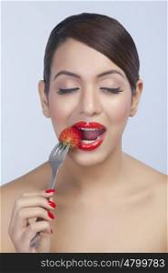 Woman taking a bite out of a strawberry