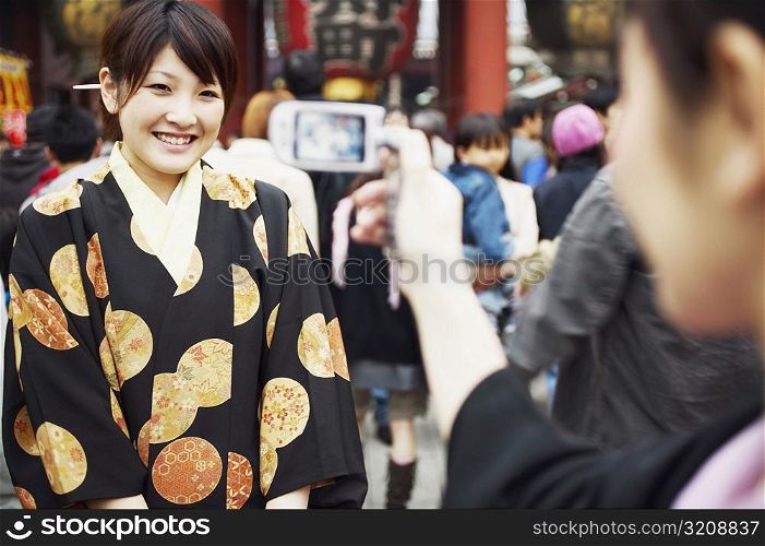 Woman taking a photograph of a young woman