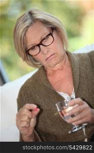 Woman taking a pill with water