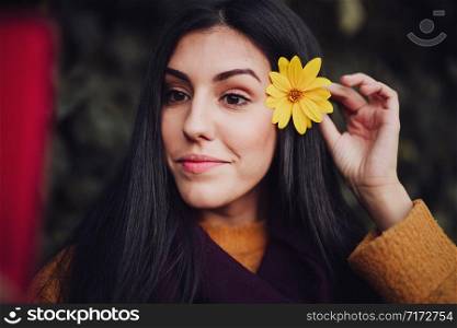 Woman taking a selfie with her phone with flower in her hair