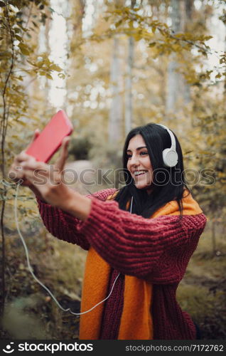 Woman taking a selfie with her phone with headphones