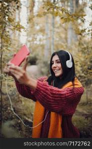 Woman taking a selfie with her phone with headphones