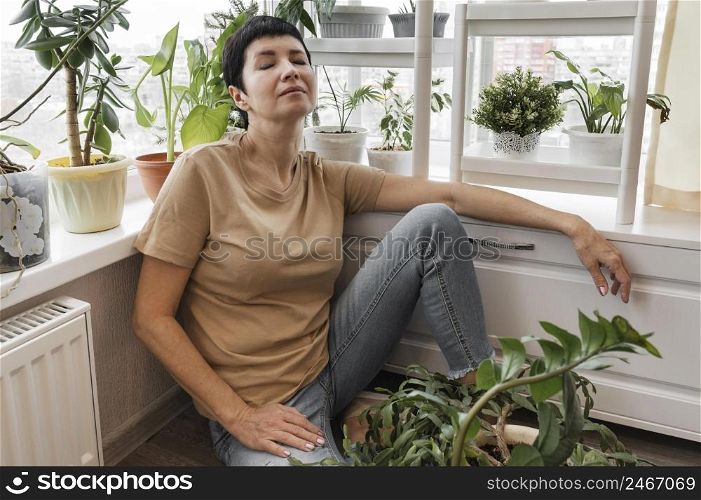 woman taking break from taking care indoor plants