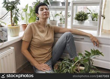 woman taking break from taking care indoor plants