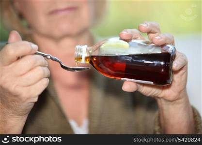 Woman taking cough medicine