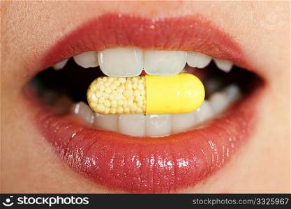 Woman taking in a pharmaceutical pill (close up on mouth) for medicine, health concept