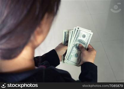 woman taking out money dollar banknotes from wallet