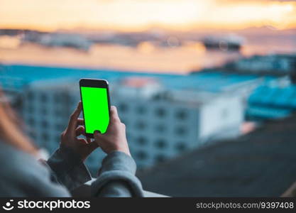 Woman taking photos with a smartphone on green screen