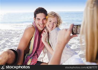 Woman taking picture of friends on beach