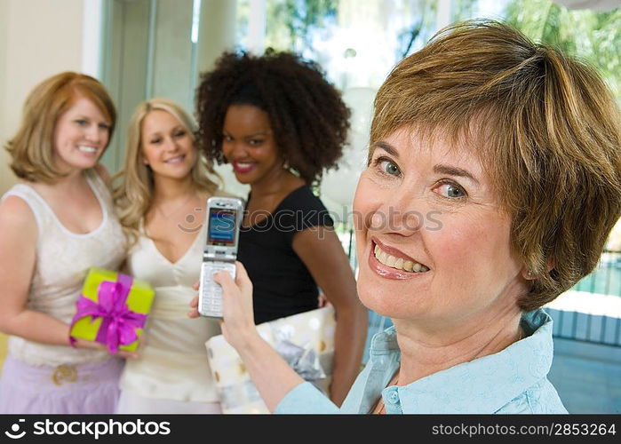 Woman Taking Pictures of women friends at Party