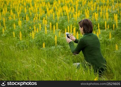 Woman taking pictures to flowers with a cellphone