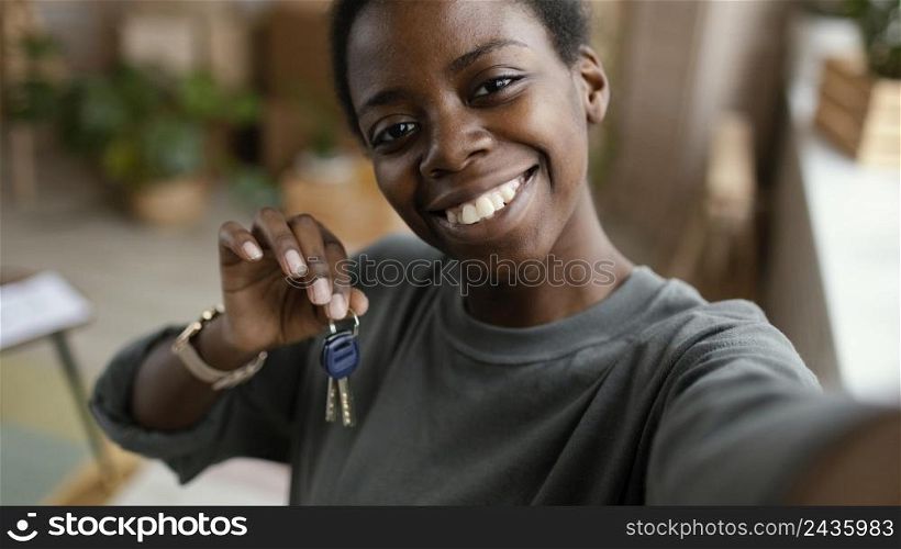 woman taking selfie while holding keys her new home