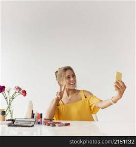 woman taking selfie while showing sign peace