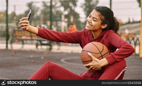 woman taking selfie with basketball