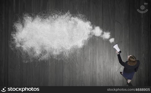 Woman talking in bullhorn. Top view of businesswoman with megaphone in hand