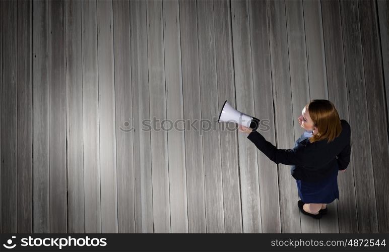 Woman talking in bullhorn. Top view of businesswoman with megaphone in hand
