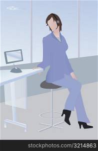 Woman talking on a headset sitting on a stool in an office