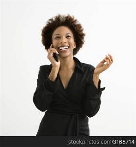Woman talking on cellphone smiling against white background.