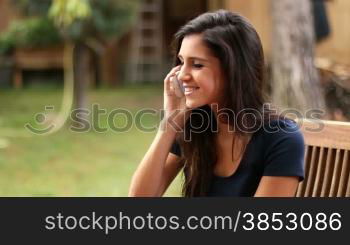 Woman talking on her smart phone.Girl on mobile conversation.Female phone conversation at home.Cellular phone chatting in leisure time.