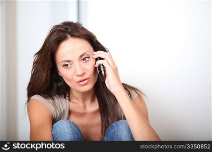 Woman talking on mobile phone at home