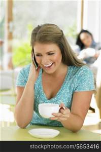 Woman Talking On Mobile Phone In Cafe