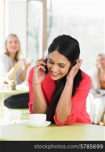 Woman Talking On Mobile Phone In Cafe