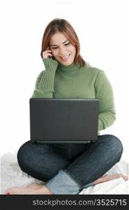 woman talking on mobile phone in front of laptop