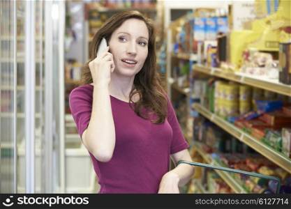 Woman Talking On Mobile Phone In Supermarket