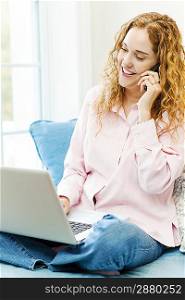 Woman talking on phone and using computer