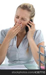 woman talking on the phone and yawning