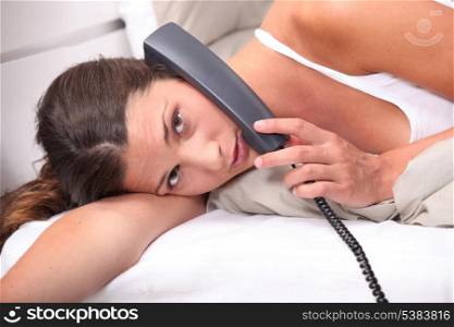 Woman talking on the phone in bed