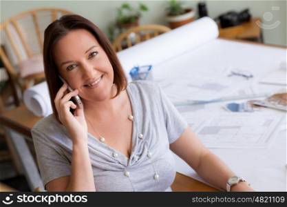 Woman talking over phone in office